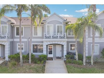 Charming townhome exterior featuring a well-manicured lawn and mature palm trees, offering a welcoming curb appeal at 18187 Paradise Point Dr, Tampa, FL 33647
