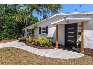 Inviting home entrance with modern black door, new landscaping, and a welcoming walkway at 331 Barbara Cir, Belleair, FL 33756