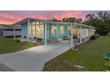 Charming blue home with a covered front porch and well-maintained landscaping in a desirable community at 35026 Colony Hills Dr, Zephyrhills, FL 33541