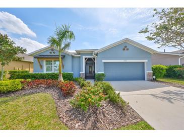 Charming single-story home featuring a beautifully landscaped front yard and a two-car garage at 6907 Crestpoint Dr, Apollo Beach, FL 33572