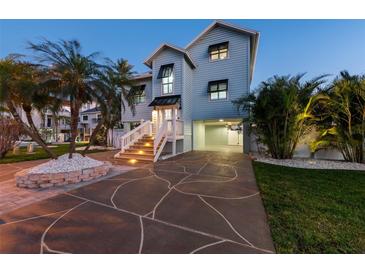 Charming two-story home featuring a paved driveway, tropical landscaping, and a welcoming entrance at 13936 Harbor View Dr, Seminole, FL 33776