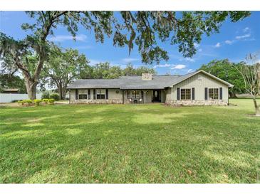 Charming single-story home with stone accents, black shutters, and a spacious front yard at 1204 Joe Henry Wheeler Dr, Dover, FL 33527