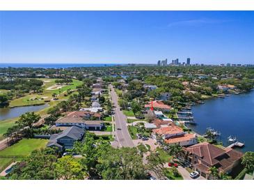 Stunning aerial view of a coastal home near a golf course and waterfront with city skyline in the distance at 1344 Monterey Ne Blvd, St Petersburg, FL 33704