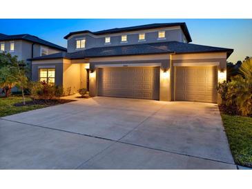 Inviting home with a three-car garage, and well lit at twilight at 18185 Cortes Creek Blvd, Spring Hill, FL 34610