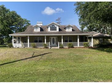 Charming single-story home with a welcoming front porch and well-maintained lawn at 18724 Geraci Rd, Lutz, FL 33548