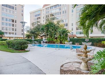 Relaxing community pool with lounge chairs and tables for entertaining in a tropical landscaped environment at 2401 S Ardson Pl # 503, Tampa, FL 33629