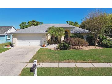 Charming single-story home with a well-manicured lawn, mature trees, and a two car garage at 15018 Greeley Dr, Tampa, FL 33625