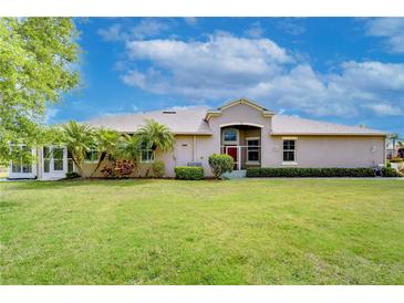 A lovely single story home with well manicured yard, tropical landscaping, and paver walkway at 2401 Richmond Greens Ct, Sun City Center, FL 33573