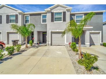 Townhome exterior features a two-car garage, and well-maintained landscaping at 2949 Suncoast Plains Dr, Odessa, FL 33556