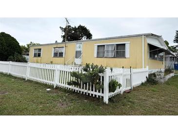 Charming single-story home featuring a white picket fence and well-maintained lawn at 4116 Cardoon Dr, New Port Richey, FL 34653