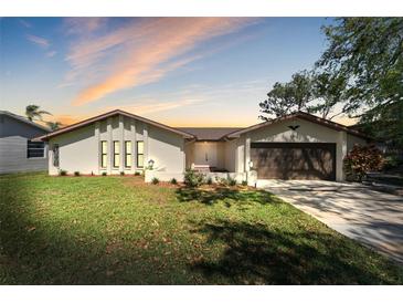 Charming single-story home with a well-manicured lawn and an attached two-car garage at 3334 Pineview Dr, Holiday, FL 34691