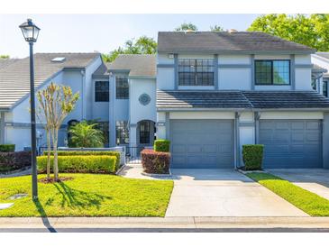 Two-story townhouse with a well-manicured lawn, gray exterior and gray garage doors at 4146 Brentwood Park Cir, Tampa, FL 33624