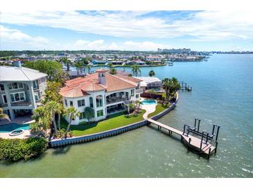 Stunning waterfront home with private dock, pool, lush landscaping, and breathtaking views of the bay at 5630 Bayview Dr, Seminole, FL 33772