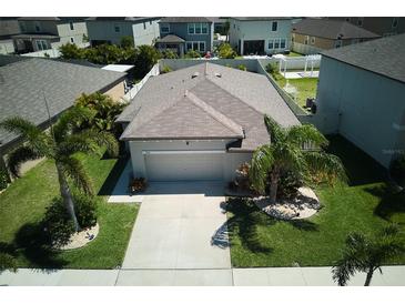 Aerial view of a single-Gathering home showcasing its well-maintained lawn and mature landscaping at 9736 Sage Creek Dr, Ruskin, FL 33573