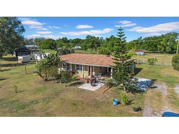 Inviting single-story home with mature trees and a cozy front patio for relaxing and entertaining at 4615 Keene Rd, Plant City, FL 33565