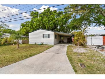 Charming single-story home with a long driveway and carport nestled amidst lush greenery and mature trees at 5832 Sussex Dr, Tampa, FL 33615