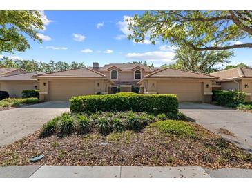 Inviting exterior view of home with attached garages, lush landscaping, and tile roof at 17557 Fairmeadow Dr, Tampa, FL 33647