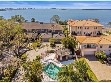 Beautiful aerial view of residences featuring a shared pool, spa and bay views at 2087 Edgewater Dr # C, Clearwater, FL 33755