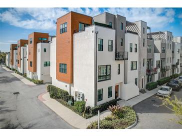 Modern townhome exterior with wood accents, a welcoming entrance, and professional landscaping at 2511 N Grady Ave # 82, Tampa, FL 33607