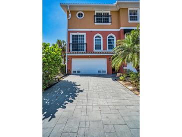 Charming multi-story home featuring a two-car garage, balcony, and well-maintained paver driveway at 47 W Morgan St, Tarpon Springs, FL 34689