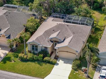 An aerial view of a one-story house featuring a well-maintained yard, screened-in pool, neutral-colored stucco, and lush landscaping at 4942 Oldham St, Sarasota, FL 34238