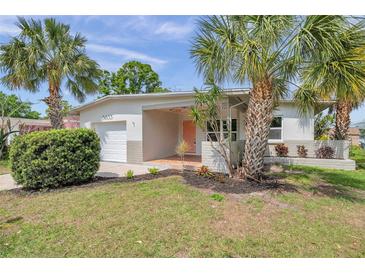 Charming home featuring mature landscaping with palm trees and a cozy front porch at 5833 Dartmouth N Ave, St Petersburg, FL 33710