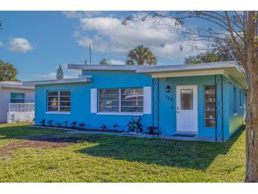 Charming single-story home with a freshly painted blue exterior, green lawn, and well-lit entry at 125 11Th Ave, Indian Rocks Beach, FL 33785
