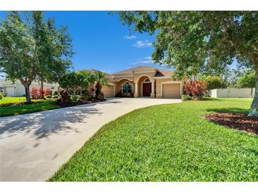 Charming single-story home with well-manicured lawn, mature trees, and a circular driveway at 12903 49Th E Ln, Parrish, FL 34219