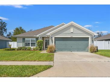 Charming single-story home featuring a well-manicured lawn and a two-car garage at 16302 Vine Cliff Ave, Hudson, FL 34667