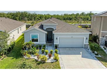 Charming single-story home boasts a meticulously landscaped front yard, enhancing its curb appeal at 16934 Oval Rum Dr, Wimauma, FL 33598