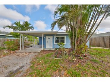 Charming blue home with a covered parking area and tropical landscaping at 3241 Williamsburg St, Sarasota, FL 34231