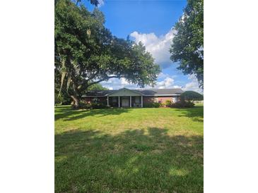 Charming single-story brick home featuring a covered porch and a lush, green lawn at 3902 Drawdy Rd, Plant City, FL 33567