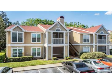 Inviting condo with a red roof, screened-in porch, and parking spaces at 9481 Highland Oak Drive # 602, Tampa, FL 33647