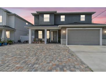 Inviting two-story home with a brick driveway and a two-car garage offers modern living at 4007 W Gray St, Tampa, FL 33609