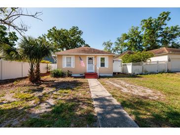 Charming single-story home featuring a welcoming walkway, fresh exterior paint, and a neatly fenced yard at 217 50Th N Ter, St Petersburg, FL 33703