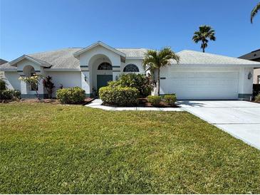 Charming single-story home with well-manicured lawn, lush landscaping and a two car garage on a sunny day at 4228 Presidential Avenue E Cir, Bradenton, FL 34203