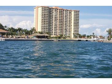 An expansive waterfront view of a high rise condo building with views of the water, docks, and tropical landscaping at 4900 Brittany S Dr # 1706, St Petersburg, FL 33715