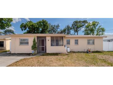 Charming single-story home with a screened porch and well-maintained landscaping and beige exterior at 6414 Larmon St, Tampa, FL 33634