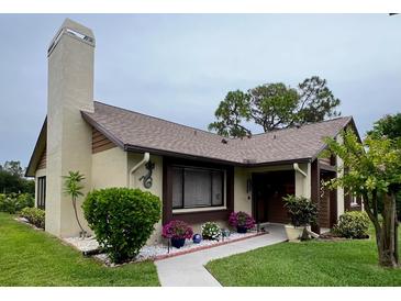 Inviting single-story home with well-maintained landscaping, complemented by colorful flowers at 2250 Sequoia Dr, Clearwater, FL 33763