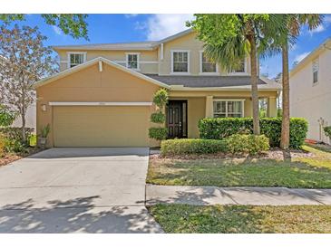 Charming two-story home with a well-manicured lawn, mature trees and a two car garage at 2935 Winglewood Cir, Lutz, FL 33558