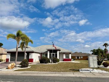 Charming single-story home featuring well-maintained landscaping and an American flag at 301 Caloosa Palms Ct, Sun City Center, FL 33573
