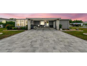 Charming single-story home with gray siding, manicured landscaping, and an extended paved driveway at 37510 New Horizons Blvd, Zephyrhills, FL 33541