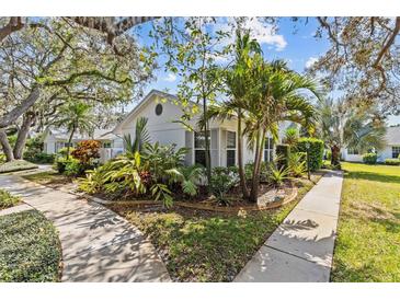A well maintained home with tropical landscaping, mature trees, and a charming exterior view at 4208 Edgewood Dr, Holiday, FL 34691