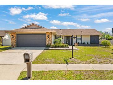 Charming single-story home with a stone-accented facade, well-manicured lawn, and inviting curb appeal at 7428 Bramblewood Dr, Port Richey, FL 34668