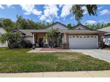 Charming single-story home with a two-car garage, landscaped yard, and inviting front porch at 7850 Lake Placid Ln, New Port Richey, FL 34655