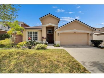 Charming single-story home featuring a well-manicured lawn, two car garage, and inviting curb appeal at 10229 Avelar Ridge Dr, Riverview, FL 33578