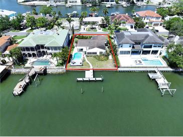 Stunning waterfront home with a private pool and dock, surrounded by lush landscaping and beautiful bay views at 5110 W Poe Ave, Tampa, FL 33629