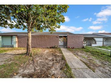 Charming home featuring a secure gated front entrance and walkway to the front door at 8325 Elkwood Ln, Tampa, FL 33615