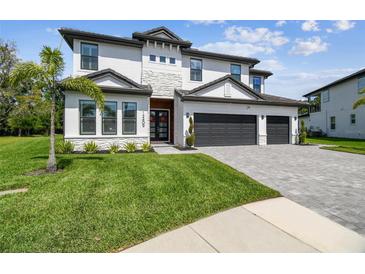 Beautiful two-story home with well-manicured lawn and three-car garage at 12409 Gentle Swan Pl, Odessa, FL 33556