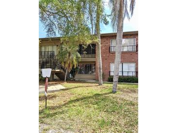 Two-story brick building with stairs, balconies, and well-maintained landscaping at 1257 Drew St # 8, Clearwater, FL 33755
